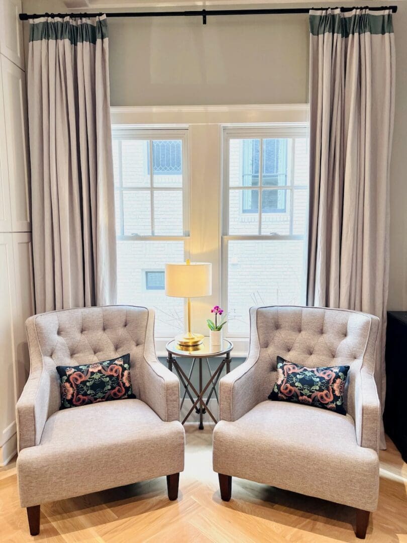 Two chairs and a table in front of a window.