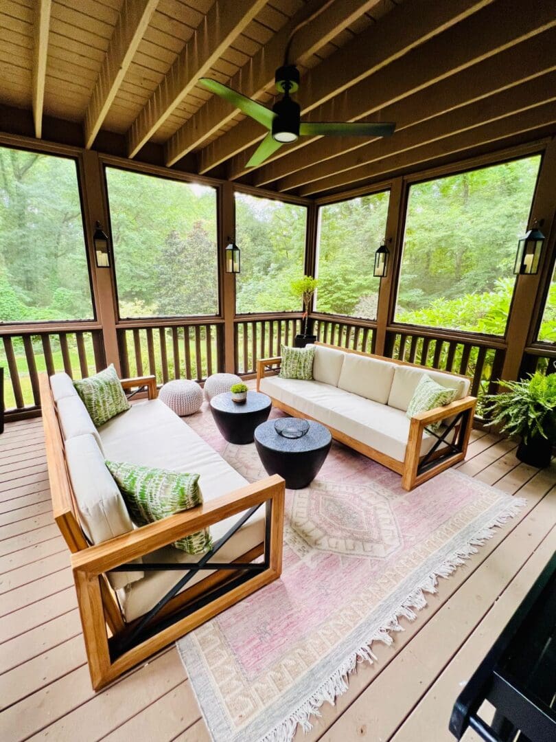 A porch with furniture and plants on the patio.