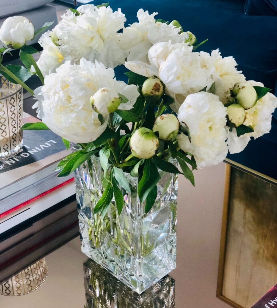 A vase filled with white flowers on top of a table.