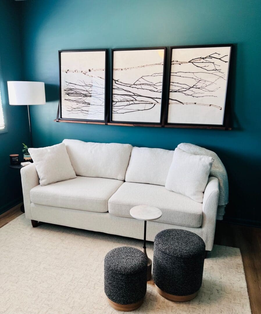 A living room with three paintings on the wall